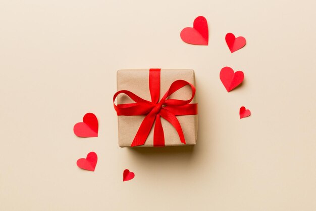 Composición del día de San Valentín Caja de regalo roja de fondo con lazo y corazón Regalo de Navidad Vista desde arriba Tarjeta de felicitación de vacaciones