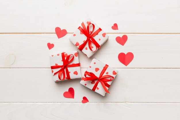 Composición del día de San Valentín Caja de regalo roja de fondo con lazo y corazón Regalo de Navidad Vista desde arriba Tarjeta de felicitación de vacaciones