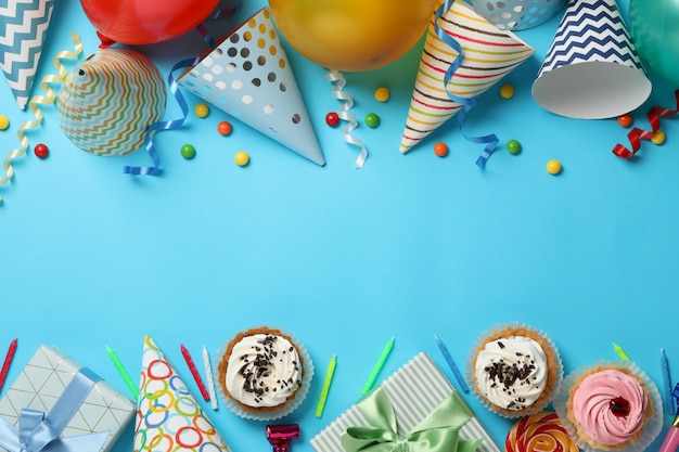 Composición con diferentes accesorios de cumpleaños sobre fondo azul, espacio para texto