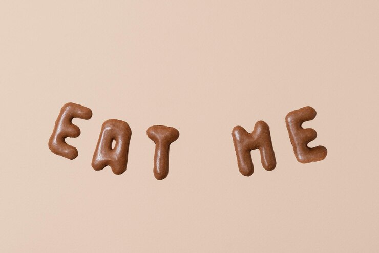 Foto composición dulce con las palabras eat me en un fondo beige biscoitos alfabéticos en un fondo pastel