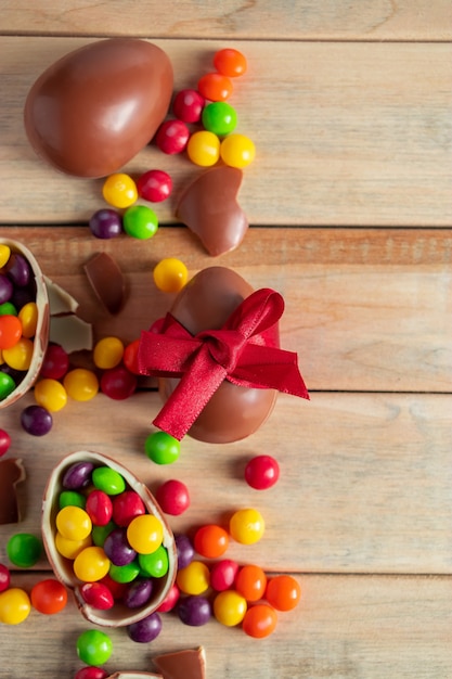 Composición de dulces de Pascua, huevos de chocolate y caramelos sobre un fondo marrón