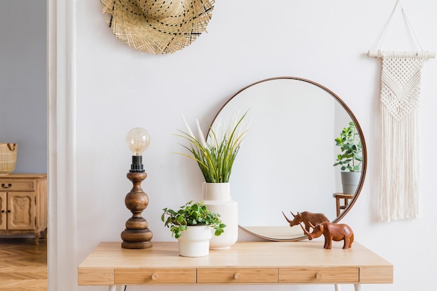 Composición elegante del interior de la sala de estar espaciosa creativa con inodoro, espejo, plantas y accesorios. Paredes blancas y suelo de parquet.