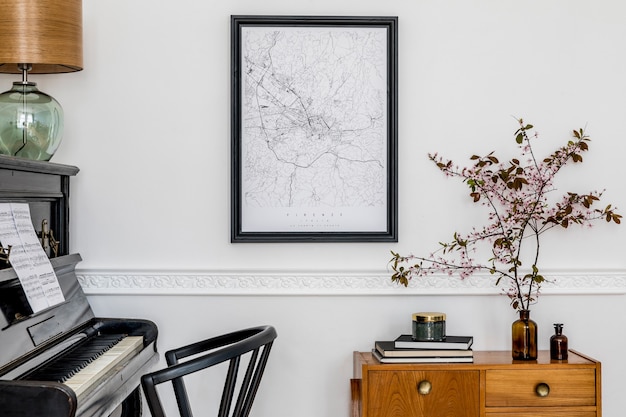 Composición elegante en el interior de la sala de estar con piano negro, silla de diseño, mapa de cartel negro, flores de primavera, lámpara, muebles y elegantes accesorios presonales en la decoración del hogar moderno