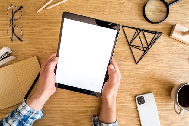 Composición empresarial moderna en la oficina en casa con autónomo, pantalla de tableta, planta, notas, teléfono móvil y material de oficina en un concepto elegante de decoración del hogar.