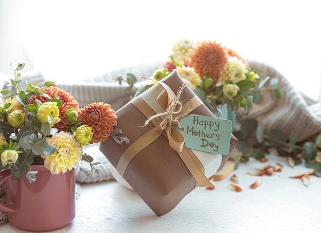 Composición festiva para el día de la madre con caja de regalo y flores.