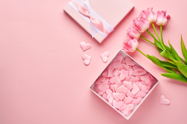 Composición festiva con hermosas flores de tulipanes delicados en caja redonda rosa sobre fondo claro