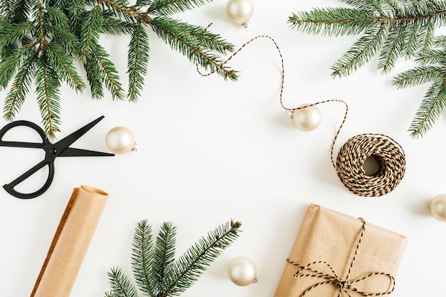 Composición festiva de Navidad con cajas de regalo, ramas de abeto y adornos en superficie blanca. Endecha plana, vista superior