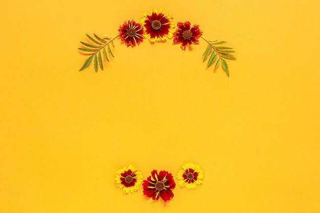 Foto composición de la flor. marco floral corona redonda de flores rojas amarillas sobre fondo naranja