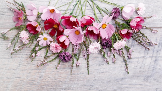 Composición de flores de color rosa púrpura sobre tablas de madera Flores silvestres sobre fondo de mesa de madera hecho a mano Telón de fondo con espacio de copia vista plana superior Concepto del día de la boda de la mujer de San Valentín de la madre