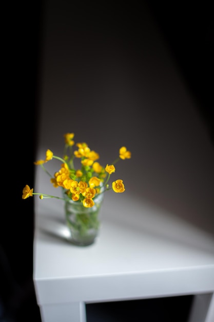 Composición de flores silvestres de color amarillo brillante en un vaso de precipitados