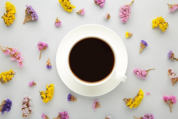 Composición de flores con taza de café