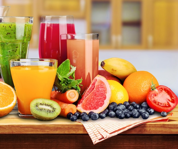 Composición de frutas y vasos de jugo en el escritorio