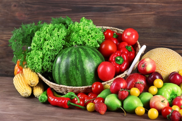 Composición con frutas y verduras frescas en mesa de madera