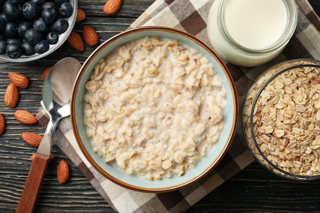 Composición con gachas de avena en la pared de madera. Cocinando el desayuno