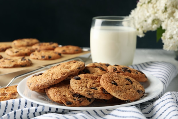 Composición con galletas de chip y leche en mesa blanca