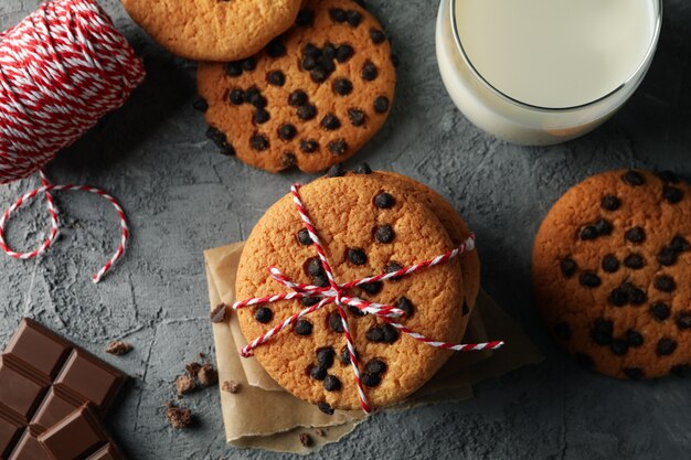 Composición con galletas de chip y leche en mesa gris