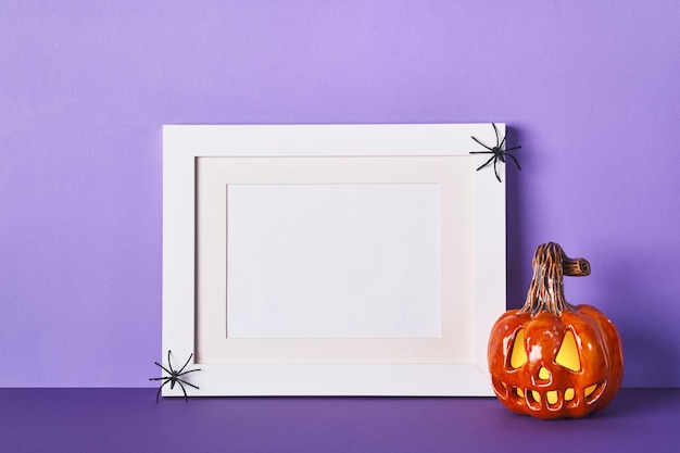 Composición de Halloween con linterna de gato de calabazas de cerámica y marco en el fondo de la pared de la mesa Plantilla de tarjeta de felicitación