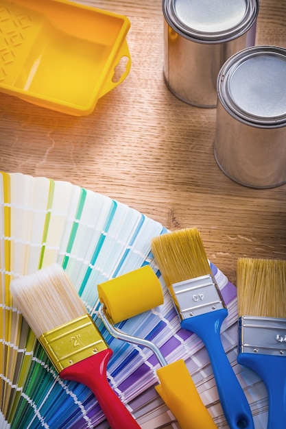 Foto composición de herramientas de pintura bandeja de rodillo de pincel puede paleta de colores sobre tabla de madera