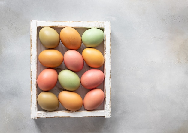 Composición laicos plana con huevos de Pascua en caja de madera blanca