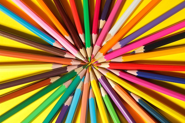 Composición con lápices de colores sobre un fondo amarillo brillante. de cerca. vista superior