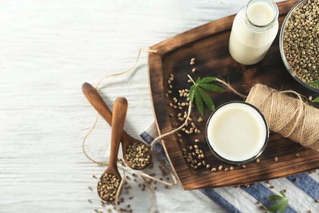 Composición con leche de cáñamo sobre mesa de madera.