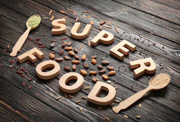 Foto composición con letras de madera y variedad de productos súper alimentarios en la mesa