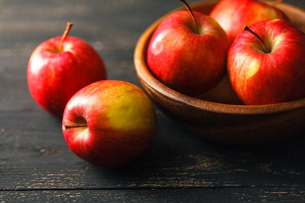 Composición con manzanas rojas en la mesa de madera oscura