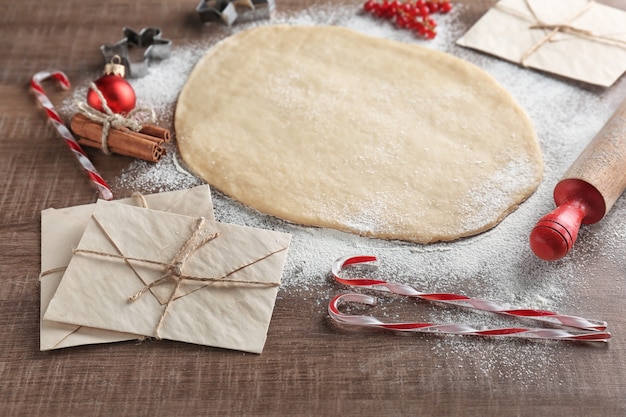 Composición con masa para galletas de Navidad en mesa de madera