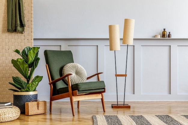 Composición minimalista en el interior de la sala de estar con sillón de diseño verde, panel beige, plantas, cubo, estantería, espacio de copia, decoración y elegantes accesorios personales en una elegante decoración del hogar.