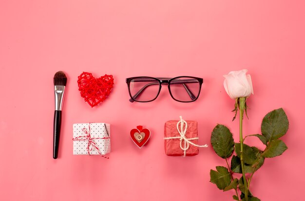 Composición de moda con accesorios de mujer sobre fondo rosa