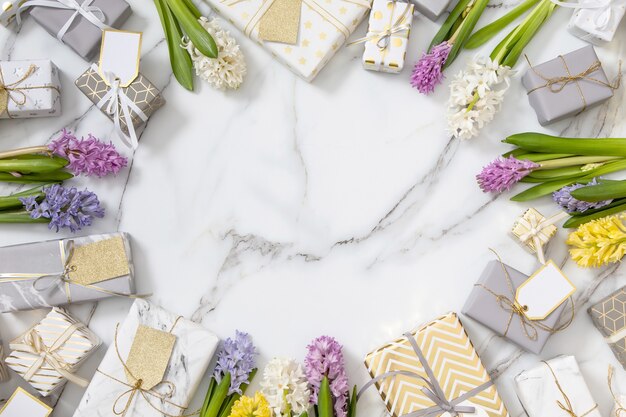 Composición de moda de vista superior con lazo de cinta de cajas de regalo envuelto festivo decorado con flores florecientes