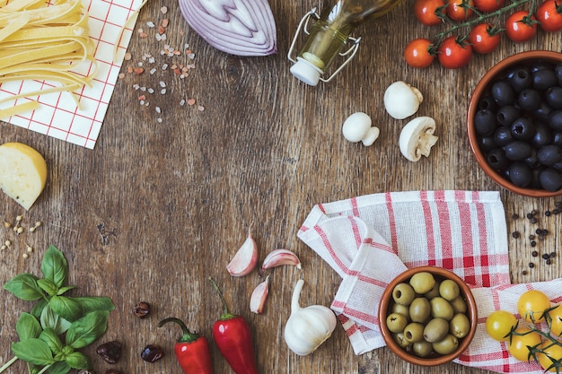 Composición moderna de alimentos e ingredientes frescos en la mesa de madera vintage en la cocina. Sabor y apariencia italianos