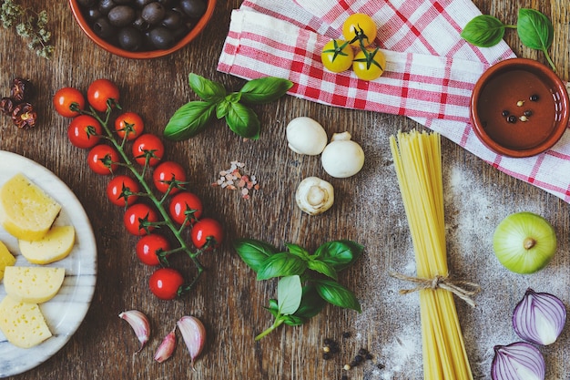 Composición moderna de alimentos e ingredientes frescos en la mesa de madera vintage en la cocina