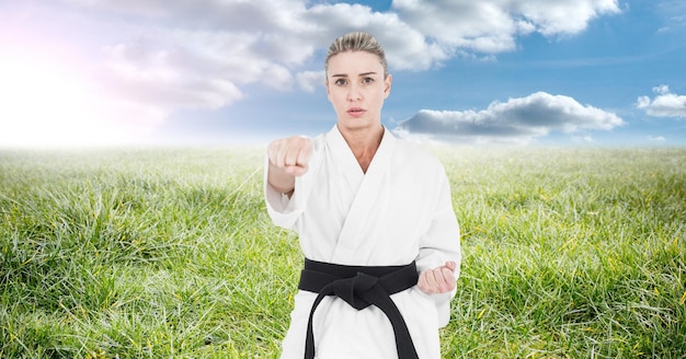 Composición de la mujer artista de karate marcial con cinturón negro practicando en el campo