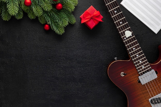 Composición de música navideña con guitarra y ramas de abeto