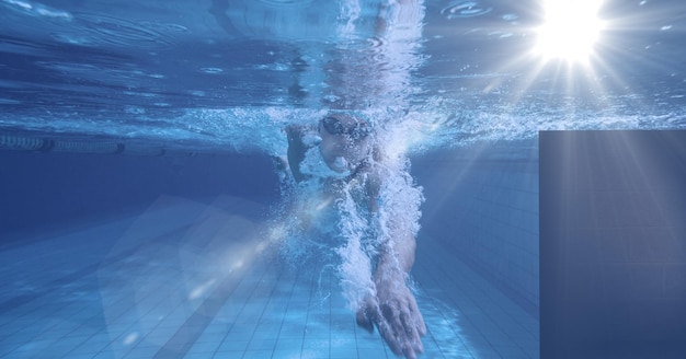 Composición del nadador masculino nadando bajo el agua con luz brillante