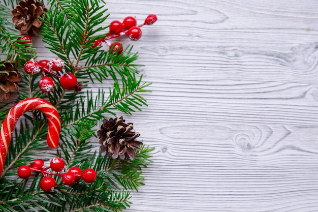 Composición de Navidad con árbol de Navidad y frutos rojos en mesa blanca