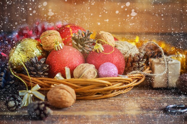 Composición de Navidad bolas rojas y amarillas, conos, en una cesta de madera