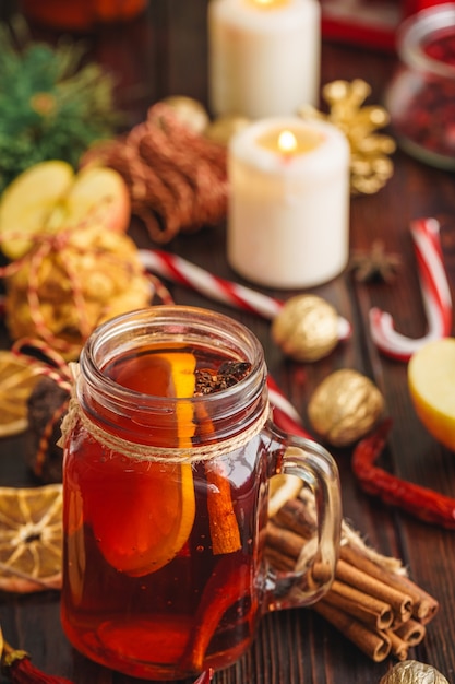 Composición de Navidad con copa de vino brillante en la mesa de madera de cerca