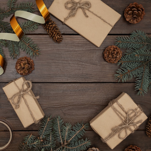 Composición de Navidad en una mesa de madera, regalos, conos de árbol de Navidad, cinta festiva, vista superior.