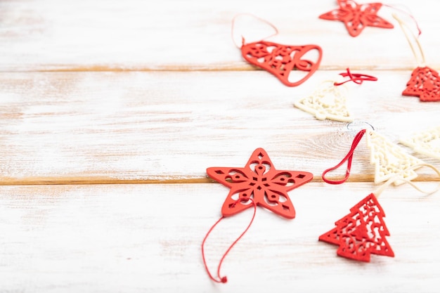 Composición de Navidad o año nuevo. Decoraciones, estrellas rojas, campanas, sobre un fondo de madera blanca. Vista lateral, espacio de copia, enfoque selectivo.