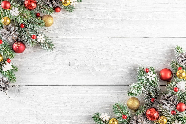 Composición de Navidad o feliz año nuevo hecha de ramas de abeto, adornos navideños sobre fondo blanco de madera. Endecha plana. Vista superior con espacio de copia.