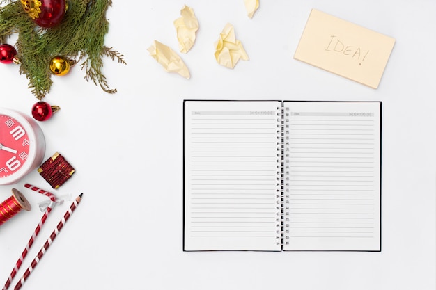 La composición de la Navidad, páginas abiertas del cuaderno, pluma, abeto ramifica en el fondo blanco. Christm