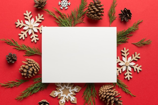Composición de Navidad plana cuadrada papel en blanco ramas de pino decoraciones navideñas en fondo de color vista superior espacio de copia para el texto