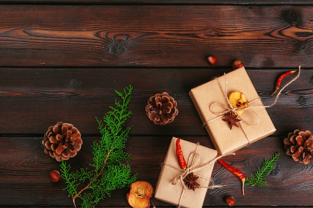 Composición de navidad Regalo navideño, manta tejida, piñas, ramas de abeto.