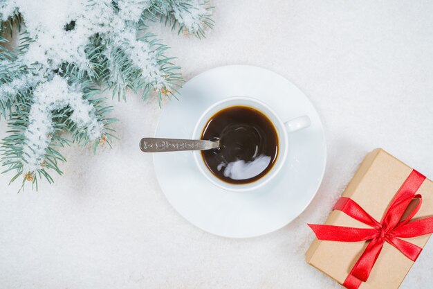 Composición de Navidad regalo ramas de abeto taza de café sobre fondo de nieve espacio de copia plana laicos