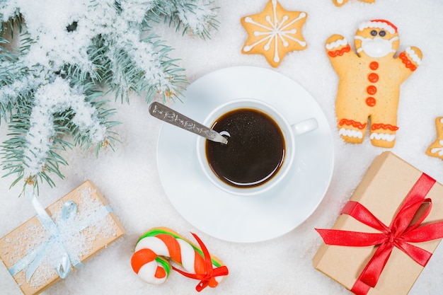 Composición de Navidad regalo ramas de abeto taza de café sobre fondo de nieve espacio de copia plana laicos