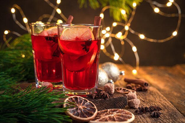 Foto composición de navidad con vino caliente sobre el fondo de luces encendidas. enfoque selectivo.