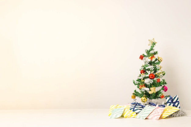 Composición navideña con adornos y caja de regalo con lazos en blanco