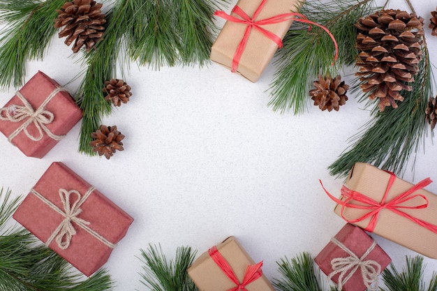 Composición navideña. Adornos navideños blancos, ramas de abeto con cajas de regalo de juguetes sobre fondo blanco. Endecha plana, vista superior, espacio de copia, tarjeta de felicitación